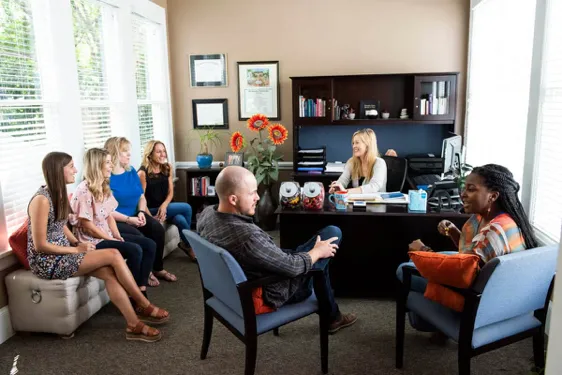 Group therapy sessions are in progress at an outpatient rehab center in Charlotte, NC, with patients and a therapist engaging in discussion.